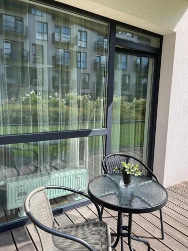a patio with a table and chairs on a balcony at Near Ozas in Vilnius
