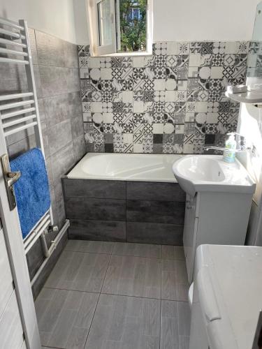 a bathroom with a tub and a sink at Apartament Rovine in Craiova