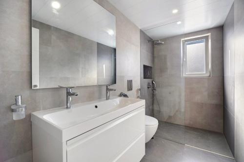 a bathroom with a white sink and a toilet at Villa Kalma in Chiclana de la Frontera