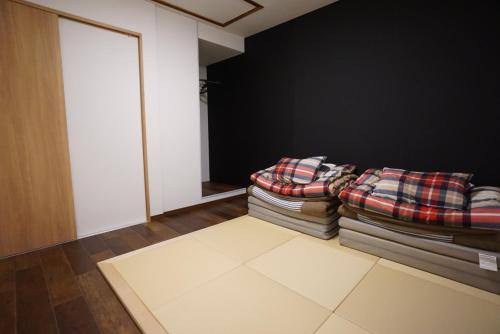 a living room with a stack of blankets and a couch at Villa Kyoto Saiin in Kyoto