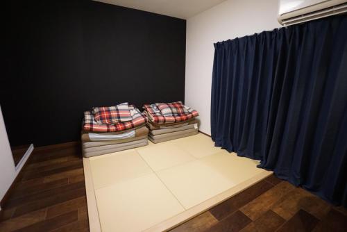 a living room with blue curtains and a couch at Villa Kyoto Saiin in Kyoto