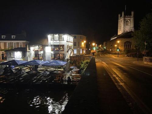 a city at night with boats in the water at Deluxe Three Bed BnB in Henley-on-Thames near Station River & Town Centre in Henley on Thames