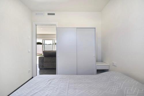 a white bedroom with a bed and a couch at Villa Kalma in Chiclana de la Frontera