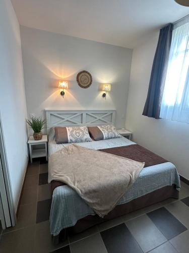 a bedroom with two beds and a clock on the wall at Appartement, château kergonano in Mériadec