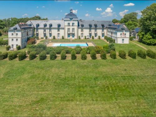 une vue aérienne d'un grand manoir avec une grande cour dans l'établissement Appartement, château kergonano, à Mériadec