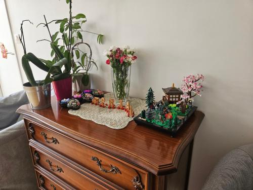 a wooden table with flowers and a vase on it at Chambre - Vanves Porte de Versailles in Vanves