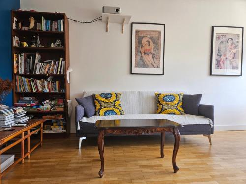 a living room with a couch and a table at Chambre - Vanves Porte de Versailles in Vanves