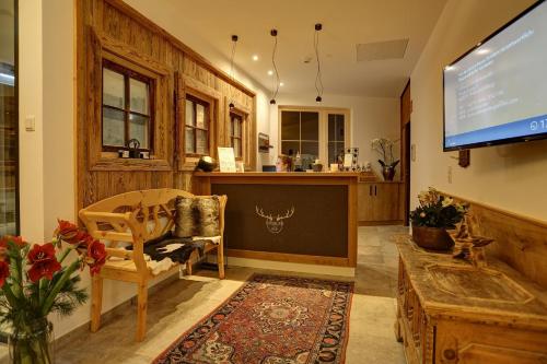 a living room with a flat screen tv and a table at Kösslerhof in Sankt Anton am Arlberg