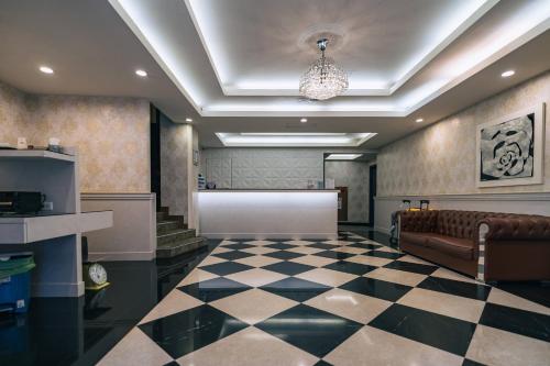 a lobby with a couch and a checkered floor at Hotel Puri in Taipei