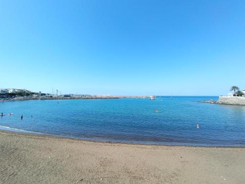 a beach with people swimming in the water at Deluxe Arguineguin Beach in Arguineguín