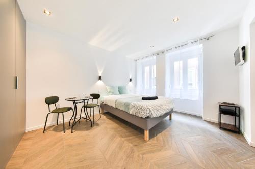 une chambre avec un lit, une table et des chaises dans l'établissement Le carré central A Mulhouse, à Mulhouse