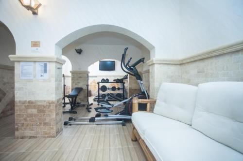 a room with a gym with a couch and exercise equipment at Pensiunea Bianca in Botoşani