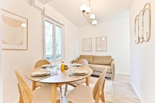 une salle à manger et un salon avec une table et des chaises dans l'établissement Appartement lumineux proche de Paris, à Asnières-sur-Seine