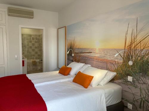 a bedroom with a bed with a painting on the wall at Praia Dria in Armação de Pêra