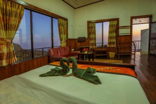 a bedroom with a bed with two swans on it at Srilak View Holiday Inn in Haputale