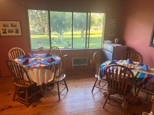 a dining room with two tables and chairs and a window at Castle Valley Inn in Moab