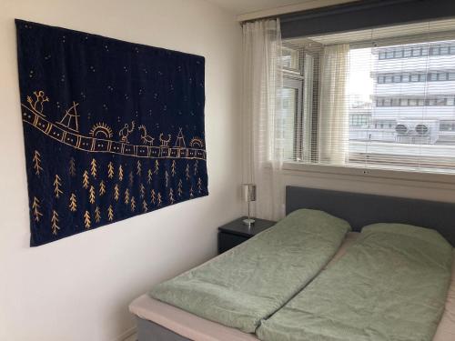 a bedroom with a bed with a blanket on the wall at Rovaniemi center apartment in Rovaniemi