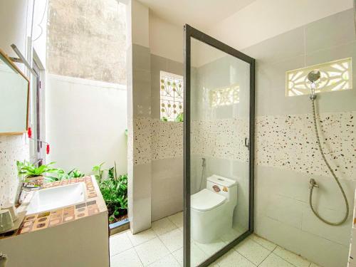 a bathroom with a shower and a toilet and a sink at DƯỚI TÁN CÂY homestay in Tây Ninh