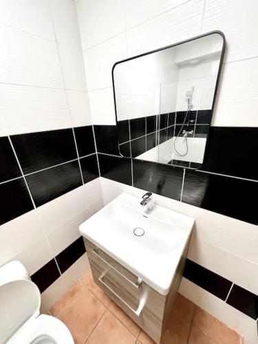 une salle de bain avec un lavabo blanc et un miroir dans l'établissement Les chambres de la bastide - 103, à Carcassonne