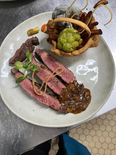 a plate of food with meat and french fries at La Sapinière St Lary Soulan in Saint-Lary-Soulan
