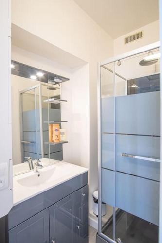 une salle de bain avec un lavabo et une douche en verre dans l'établissement L'Appel de la mer - Front de mer Parking privatif, à Étretat