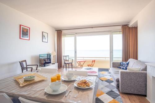 un salon avec une table avec de la nourriture dessus dans l'établissement L'Appel de la mer - Front de mer Parking privatif, à Étretat