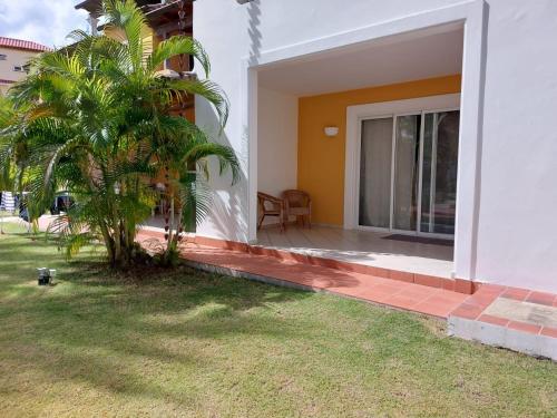 a house with a palm tree in front of a window at Tamarindo in Bayahibe