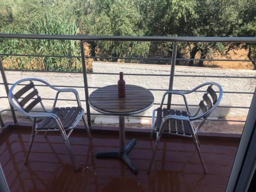 a table with a bottle of wine sitting between two chairs at Helen in Pírgos Psilonérou