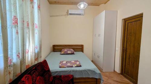 ein kleines Schlafzimmer mit einem Bett und einem Fenster in der Unterkunft Green Corner in Tbilisi City