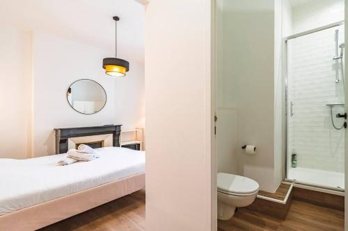 - une chambre avec un lit, des toilettes et un miroir dans l'établissement Pink, Appartement en plein cœur de Reims, à Reims
