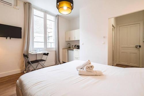 - une chambre avec un lit blanc et une serviette dans l'établissement Pink, Appartement en plein cœur de Reims, à Reims