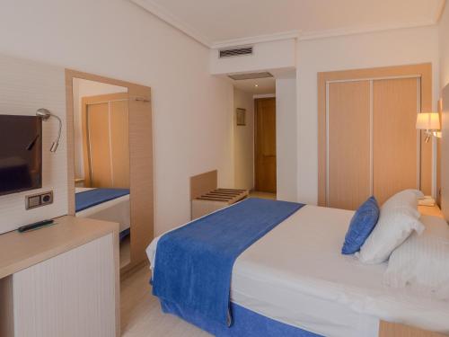 a hotel room with a bed and a television at Ipanema Park in El Arenal