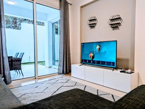 a living room with a flat screen tv on a white cabinet at Holiday Cyprus 001 in Polis Chrysochous