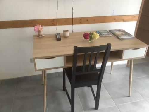 a wooden table with a black chair at a desk at Gite Augirons in Saint-Ciers-sur-Gironde