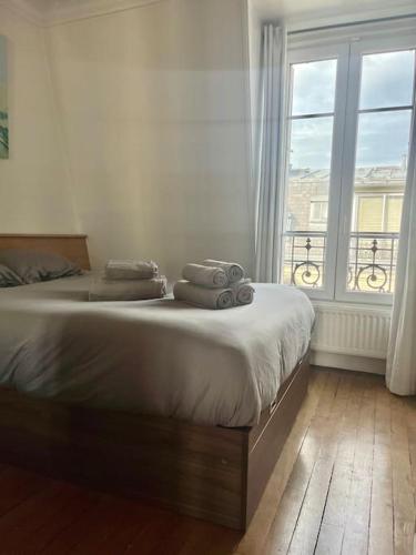 - une chambre dotée d'un lit avec serviettes et d'une fenêtre dans l'établissement Appartement de charme, terrasse et vue Tour Eiffel, à Paris