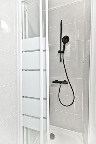 une douche avec pommeau de douche dans une salle de bain dans l'établissement Appartement lumineux proche de Paris, à Asnières-sur-Seine