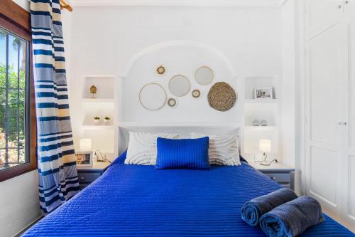 a bedroom with a blue bed with blue pillows at REFUGIO by the Sea in Orihuela