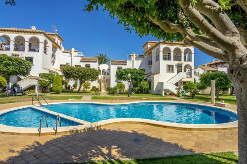 a swimming pool in front of a large building at REFUGIO by the Sea in Orihuela