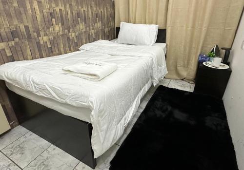 a bed with white sheets and towels on it at Phenomenal Room "Sea View" in Abu Dhabi