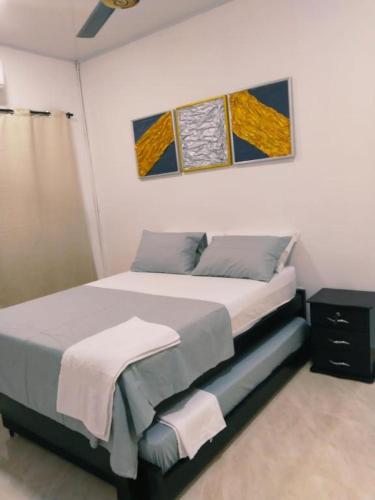 um quarto com uma cama e uma pintura na parede em Apartamento Capri 1 em Puerto Triunfo