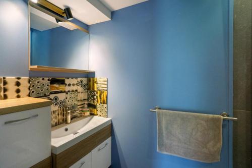 a blue bathroom with a sink and a mirror at Chez Anna in Saint-Jean-de-Maurienne