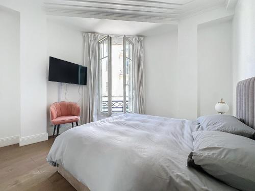 - une chambre blanche avec un lit et une chaise rouge dans l'établissement INTUITION - 2 pieces - Cannes Carre d or, à Cannes