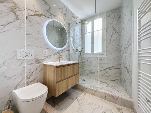 une salle de bain avec toilettes, lavabo et miroir dans l'établissement INTUITION - 2 pieces - Cannes Carre d or, à Cannes