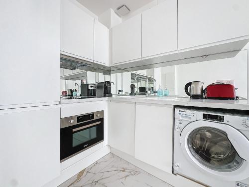 une cuisine blanche avec une machine à laver à l'intérieur dans l'établissement INTUITION - 2 pieces - Cannes Carre d or, à Cannes