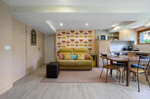 a living room with a yellow couch and a table at Chez Anna in Saint-Jean-de-Maurienne