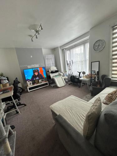 a bedroom with a bed and a flat screen tv at 1 bedroom house, Seven Sisters, Tottenham in London