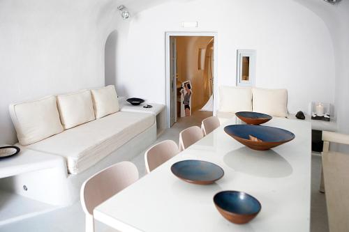 a living room with a white couch and bowls on a table at Santoniro Villa in Fira