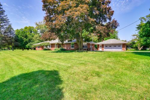 a house with a tree in front of a yard at Home about 17 Mi to Detroit with Patio and Grill! in Southfield