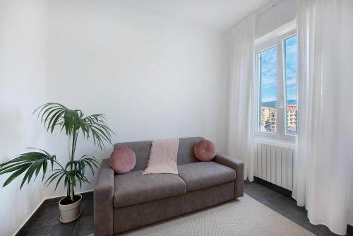 a living room with a couch and a plant at Casa Alba La Casa Delle Coccole in Savona