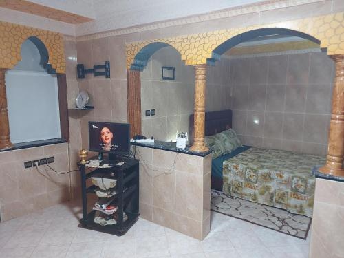 a room with a bed and a table with a picture at Airport Agadir Guest House in Agadir